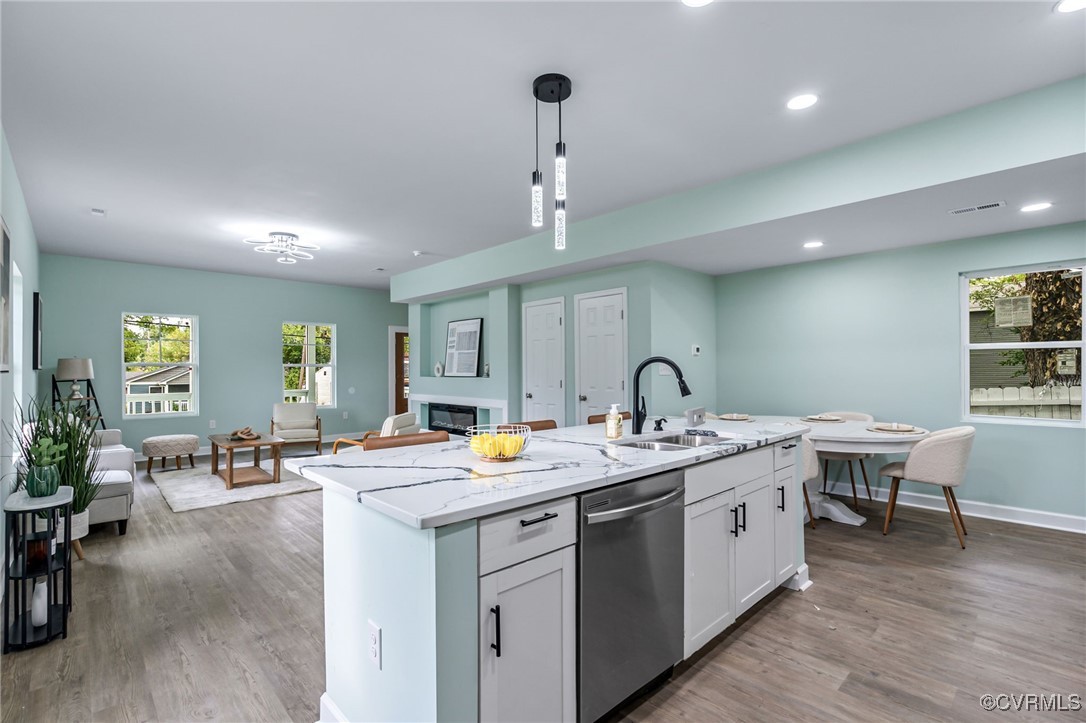 a view of a kitchen with kitchen island a sink a stove and wooden floors