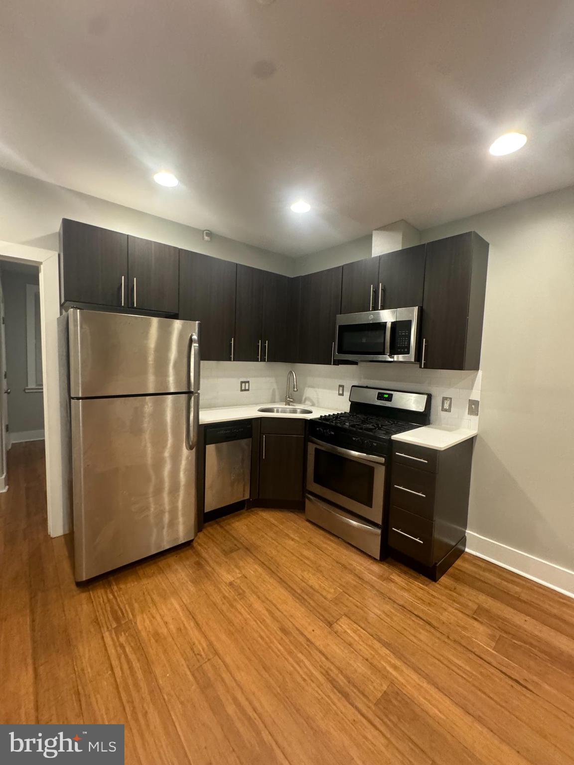 a kitchen with stainless steel appliances wooden floors and wooden cabinets