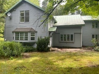 a front view of house with yard and trees in the background