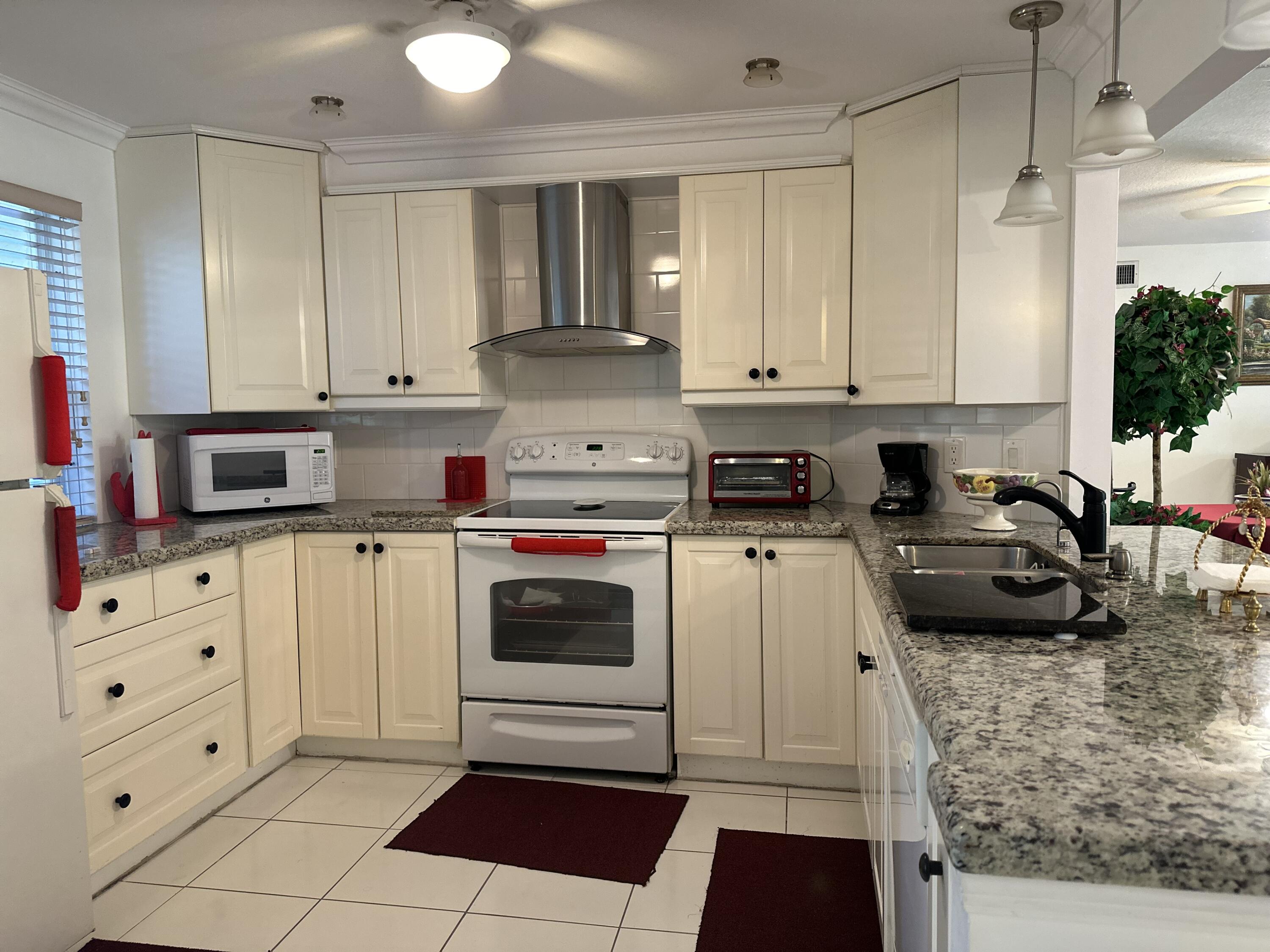 a kitchen with white cabinets and appliances