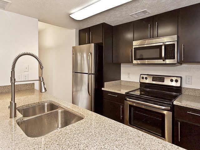 a kitchen with a sink stove and refrigerator