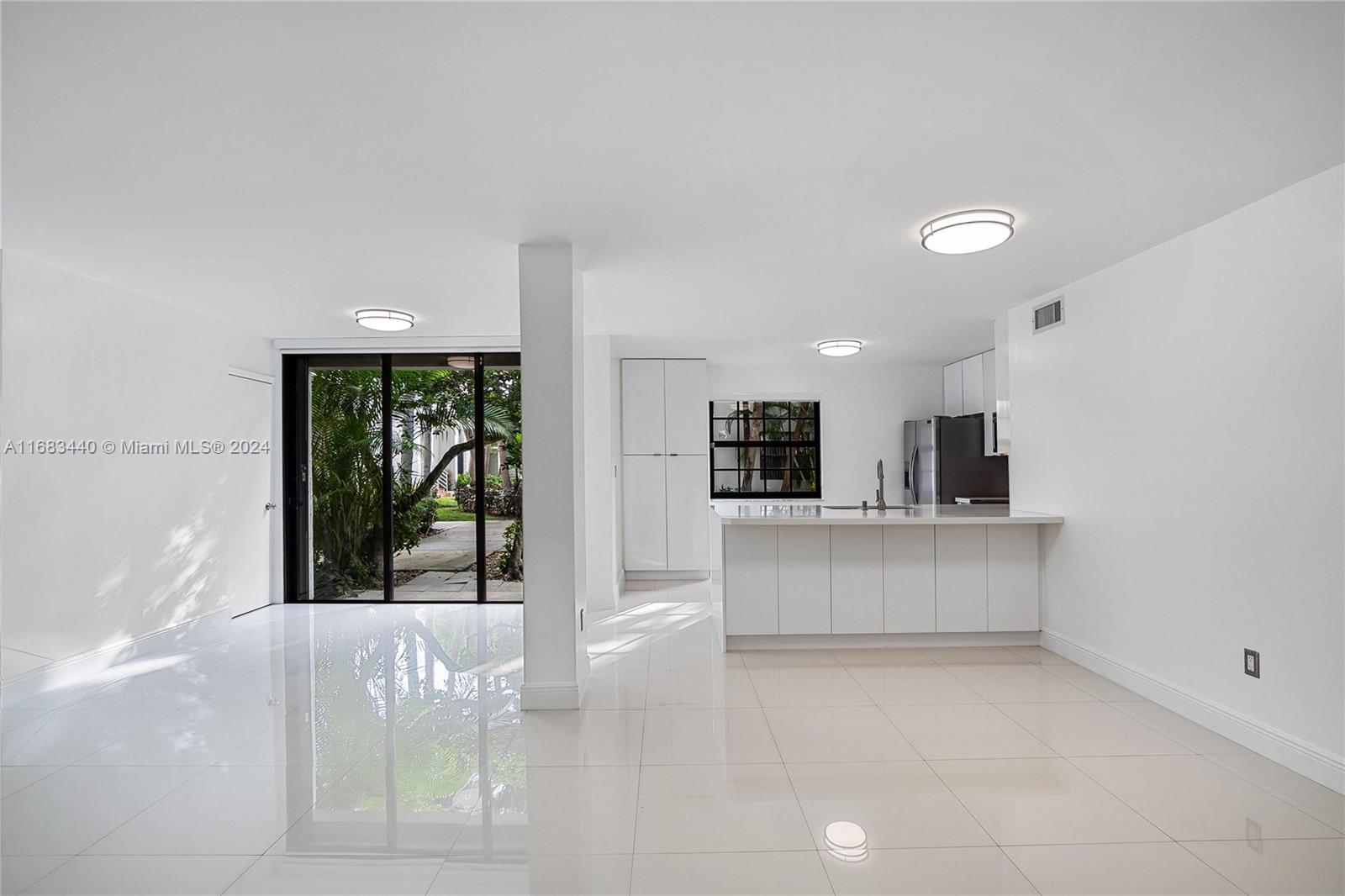 a view of kitchen with stainless steel appliances kitchen island sink and refrigerator