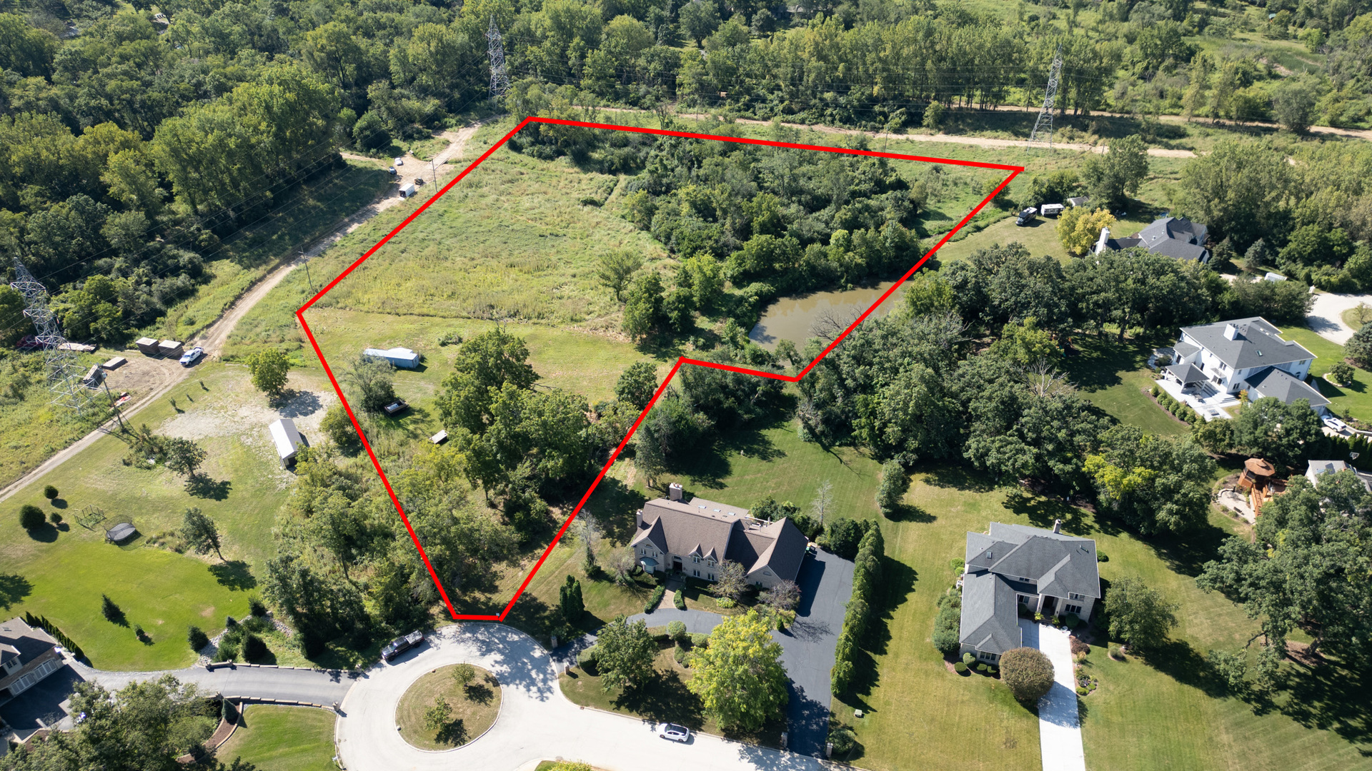 an aerial view of a house with a yard and lake view