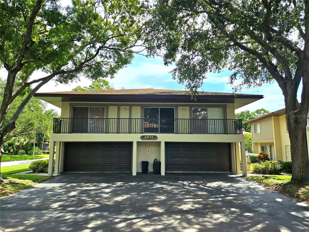 a front view of a house with yard and parking