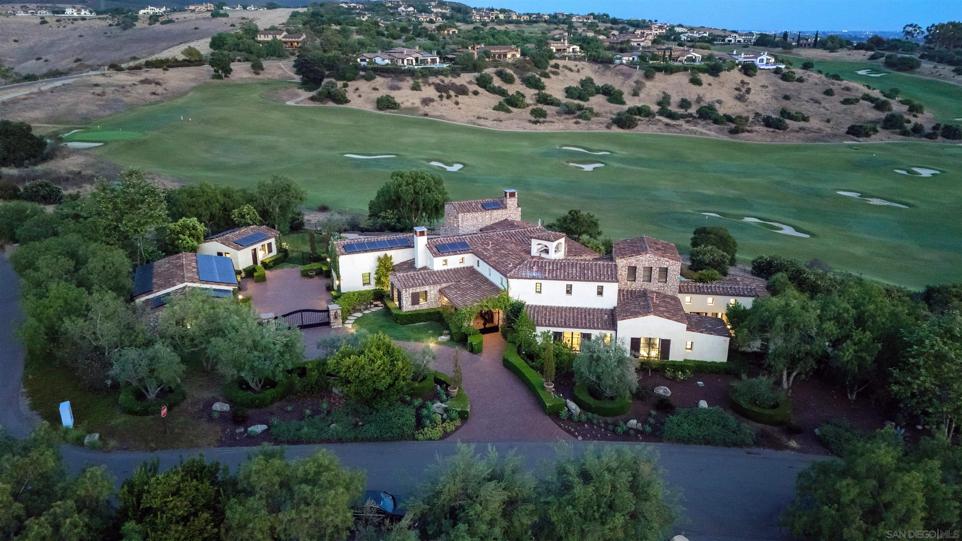 an aerial view of residential houses with outdoor space and trees