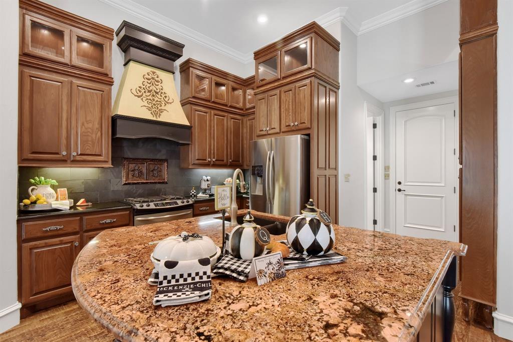 a kitchen with stainless steel appliances granite countertop a sink refrigerator and cabinets