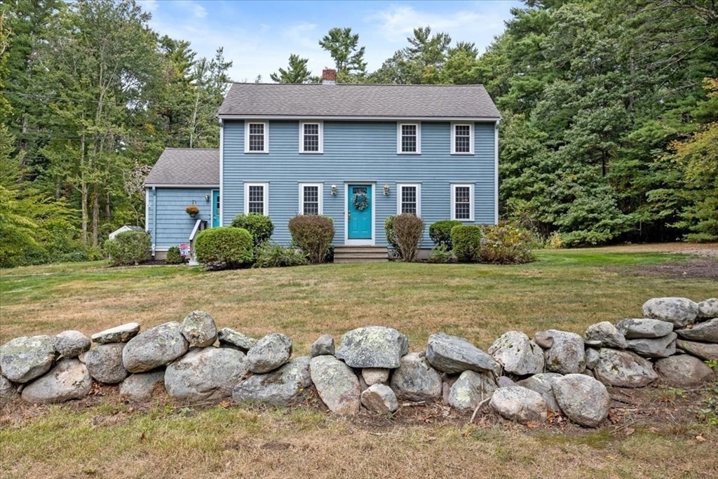 a front view of house with yard and trees around