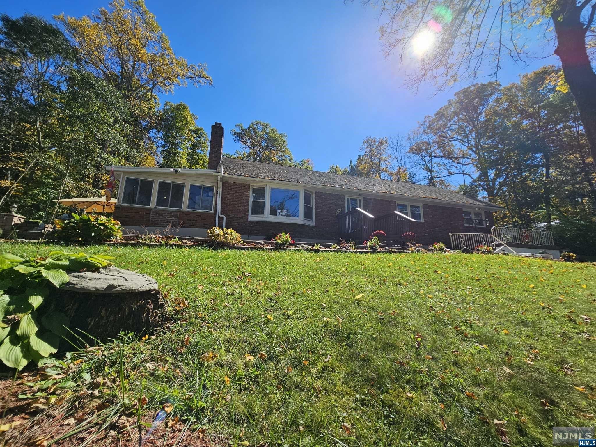 a front view of a house with a yard and a garden