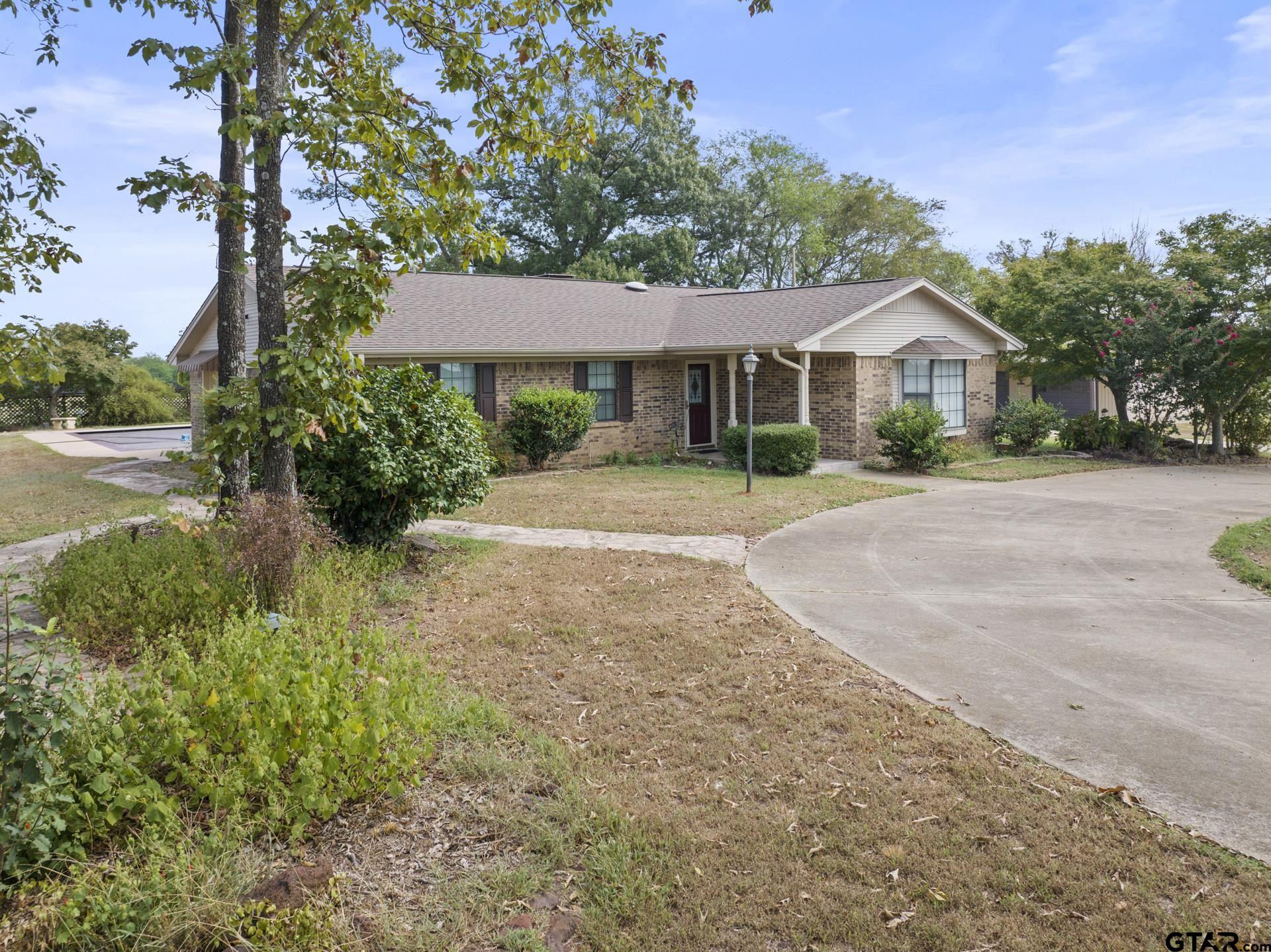 a front view of a house with a yard and potted plants