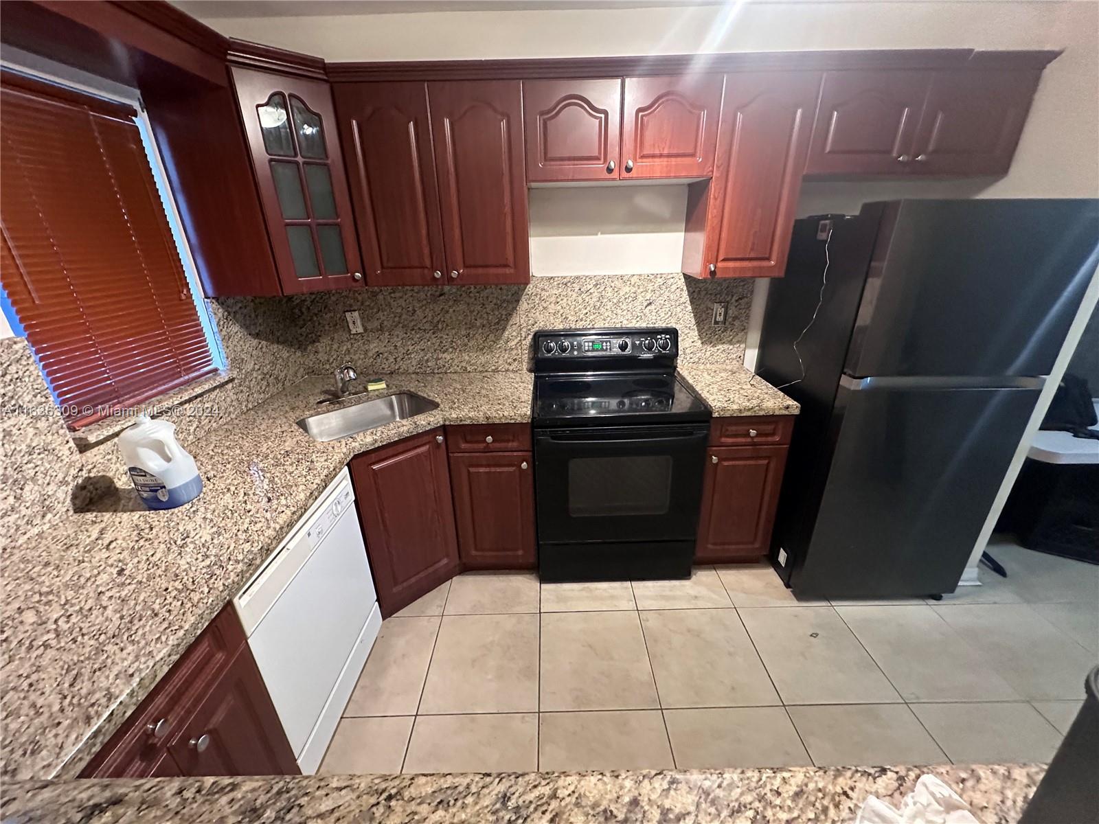 a kitchen with a refrigerator and a stove