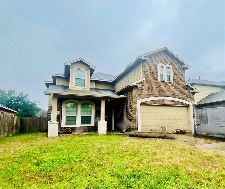 a front view of a house with a garden and garage