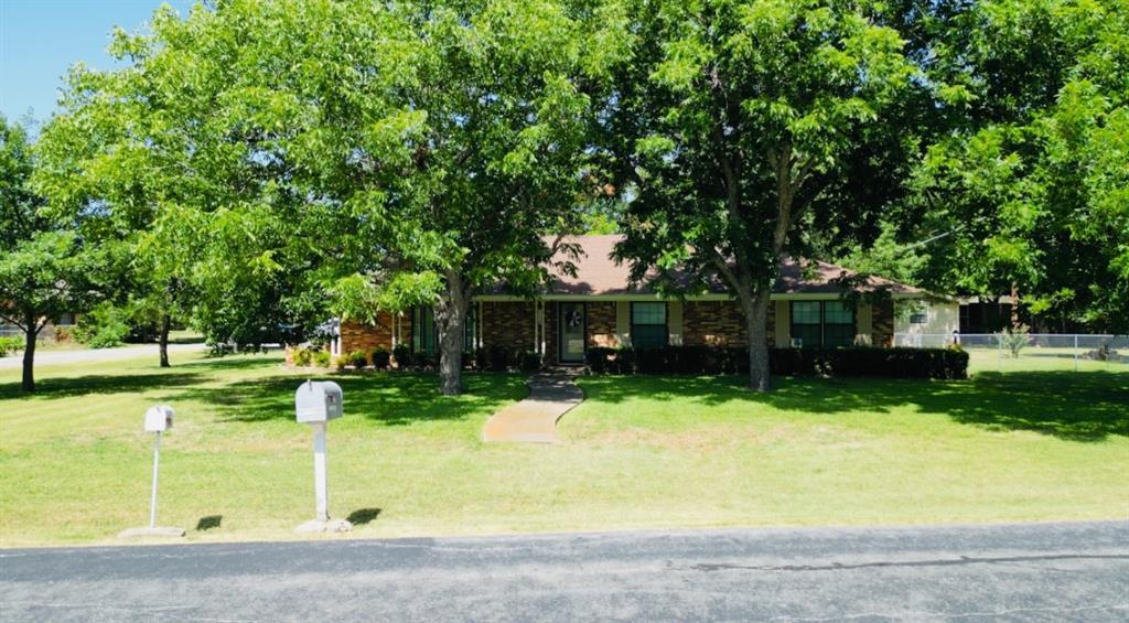 a front view of a house with a yard and trees