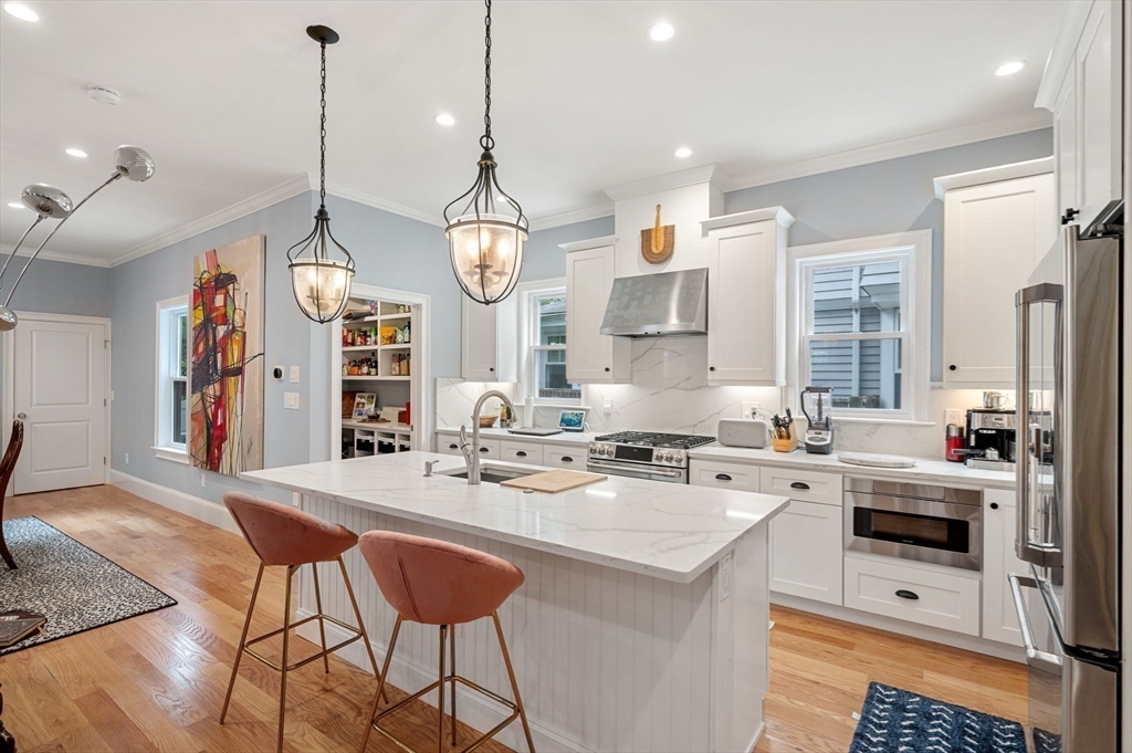 a kitchen with stainless steel appliances a stove a sink a dining table and chairs