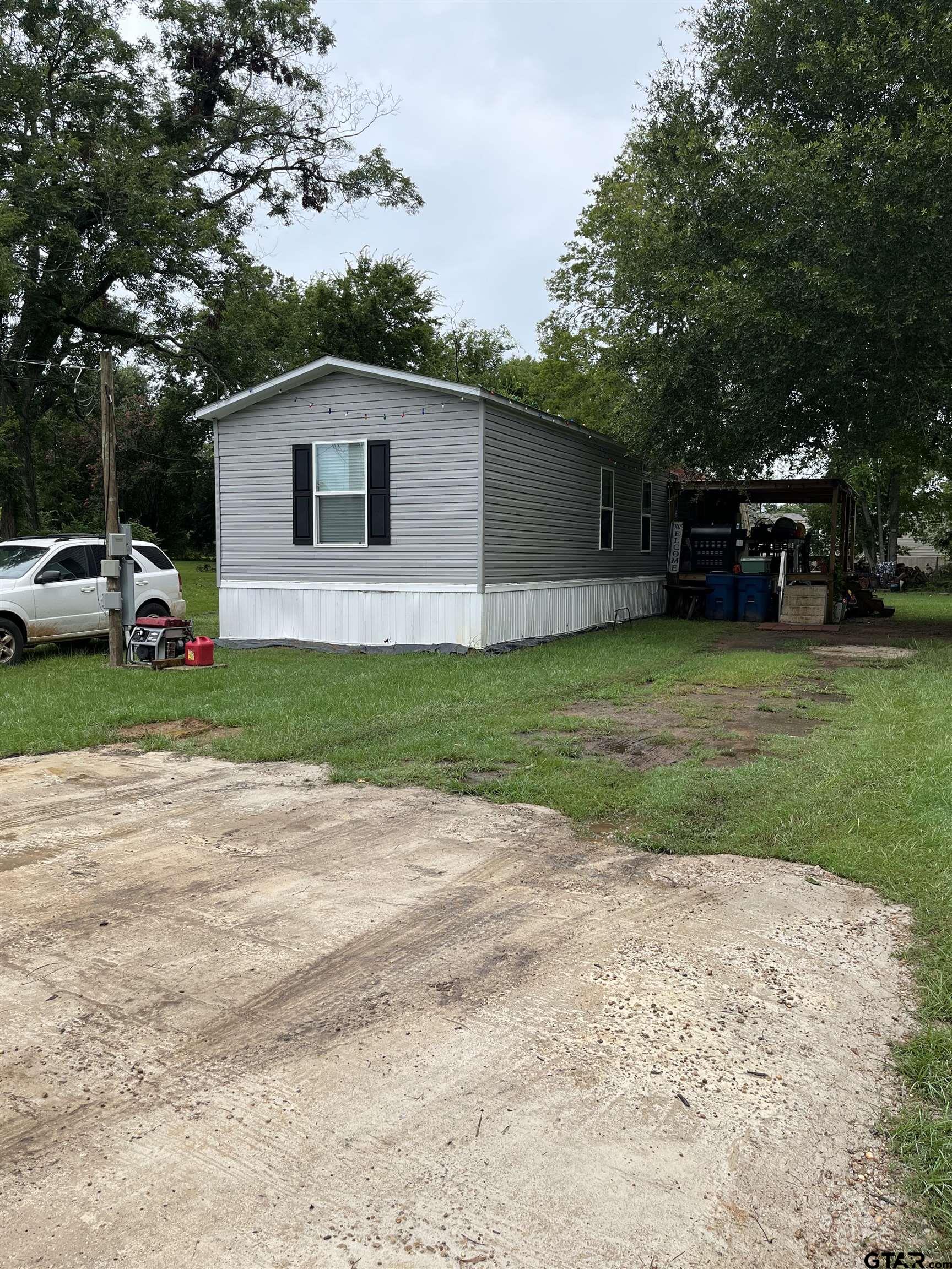 a view of a house with backyard and a car parked