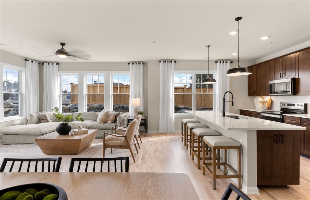 a living room with furniture a flat screen tv and large windows