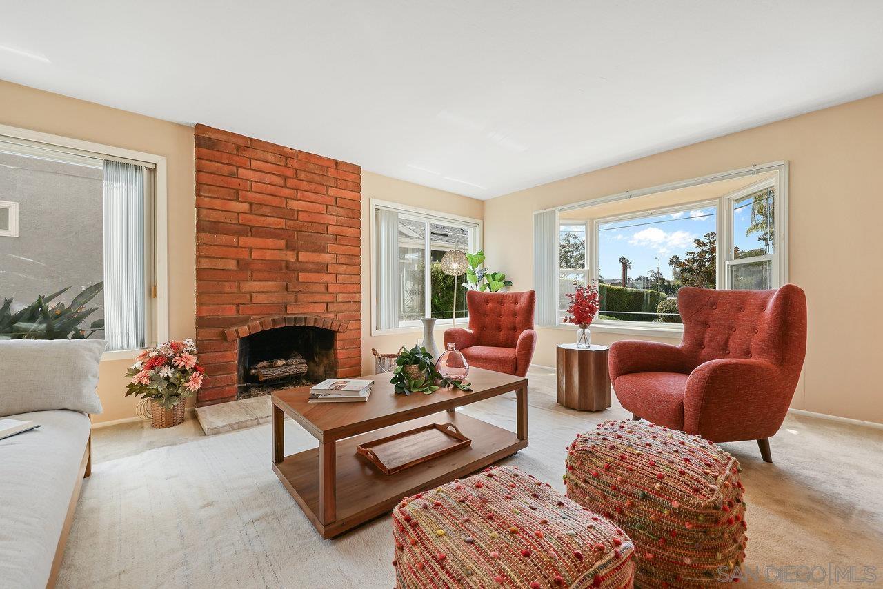 a living room with furniture a rug a fireplace and windows