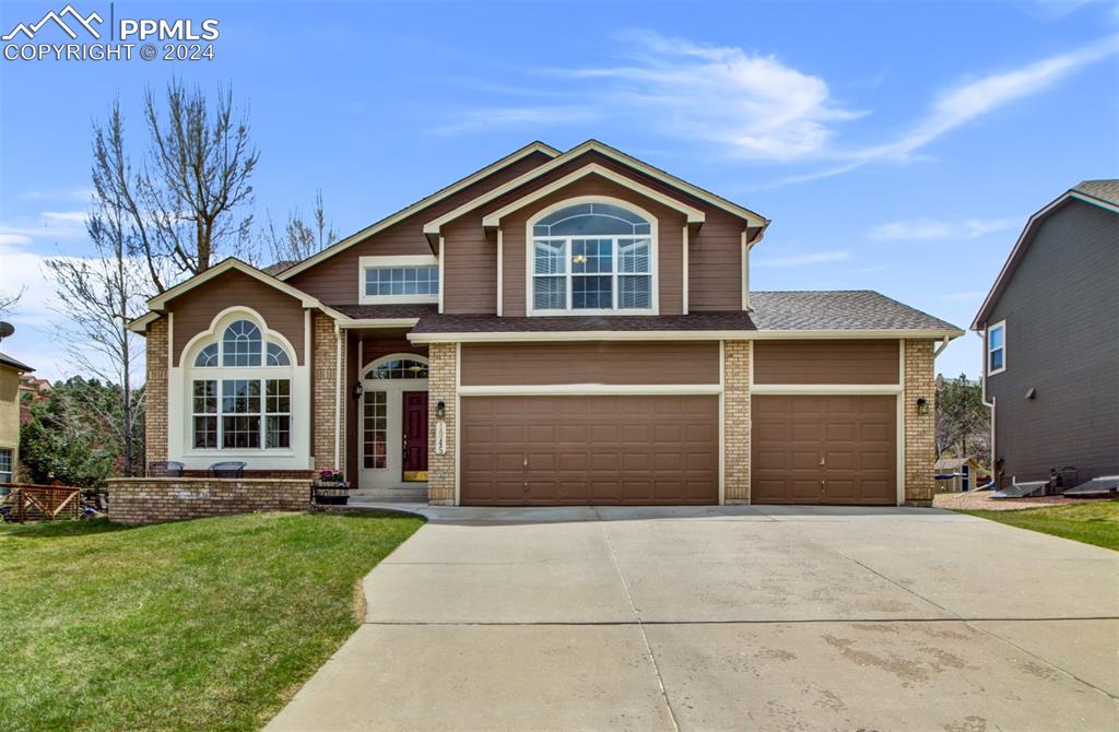 a front view of a house with a yard and garage