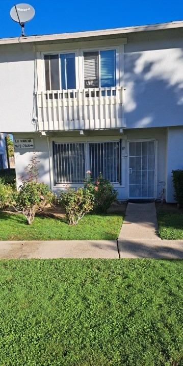 a front view of a house with a yard and a fence