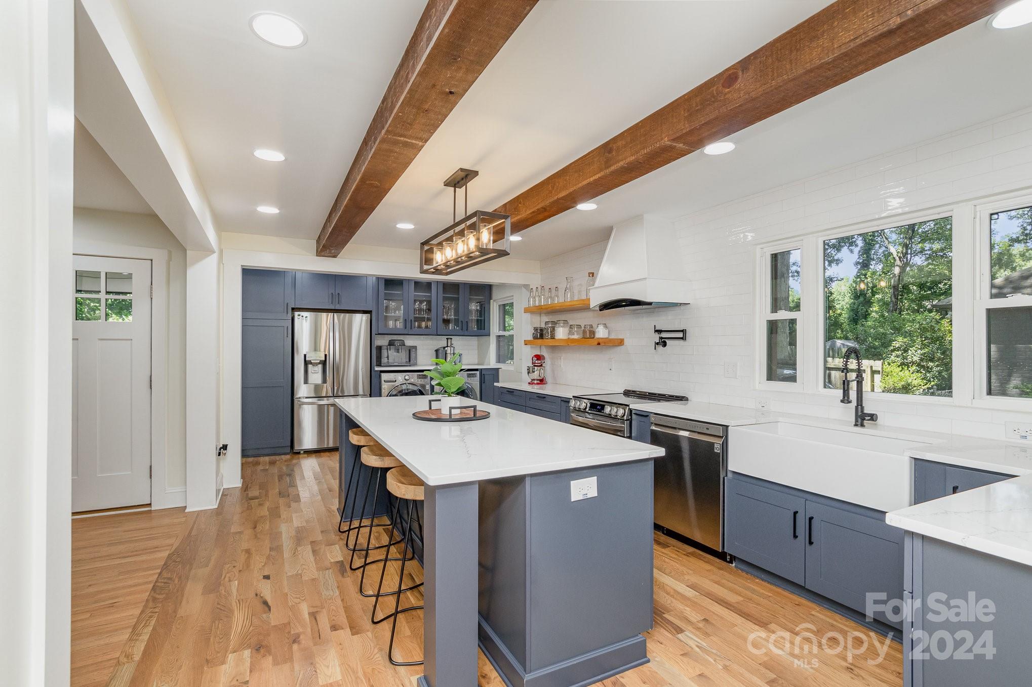 a kitchen with stainless steel appliances granite countertop a sink stove and refrigerator