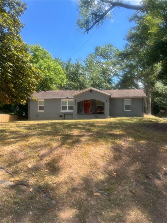 a front view of house with yard and trees in the background