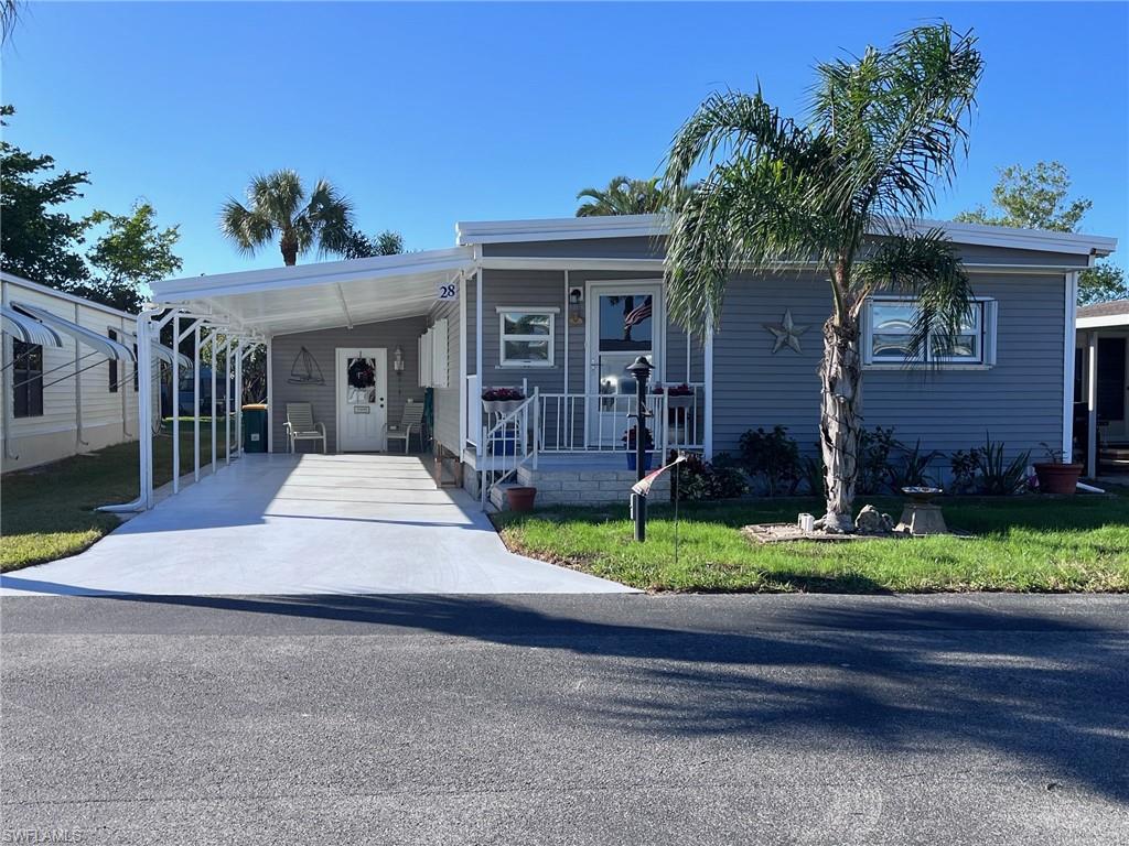 Manufactured / mobile home with a carport and a front lawn