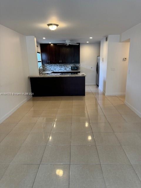 a view of kitchen with kitchen island stainless steel appliances a sink cabinets and a counter top space