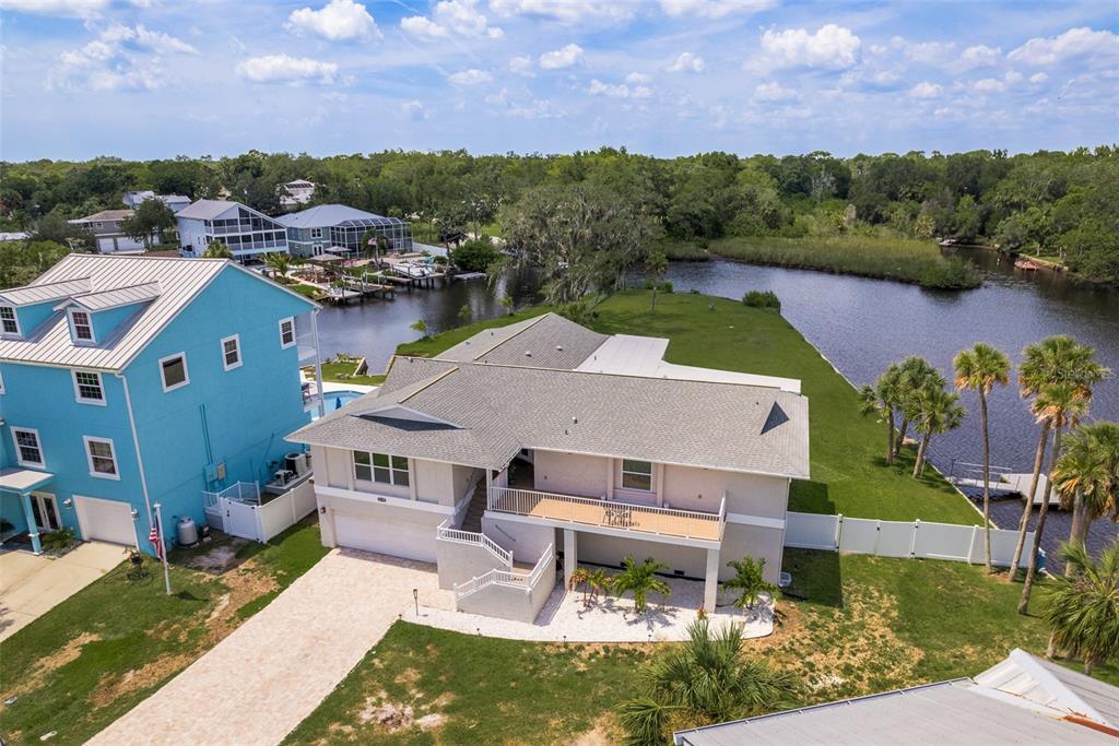 an aerial view of a house with a garden and lake view