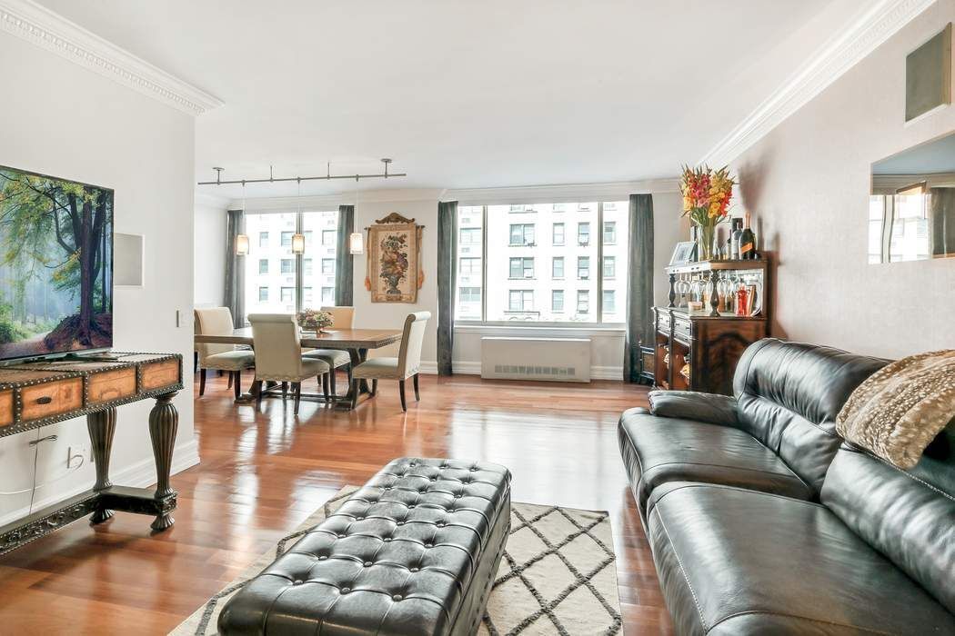 a living room with furniture and a flat screen tv with wooden floor