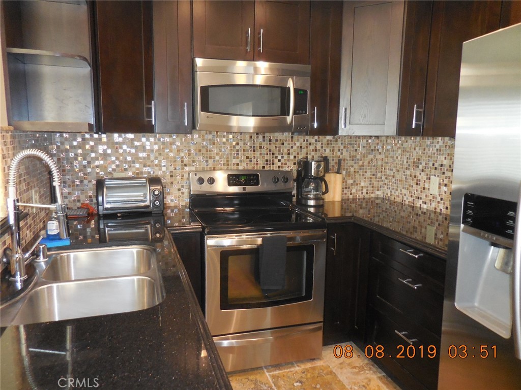 a kitchen with a sink and steel appliances