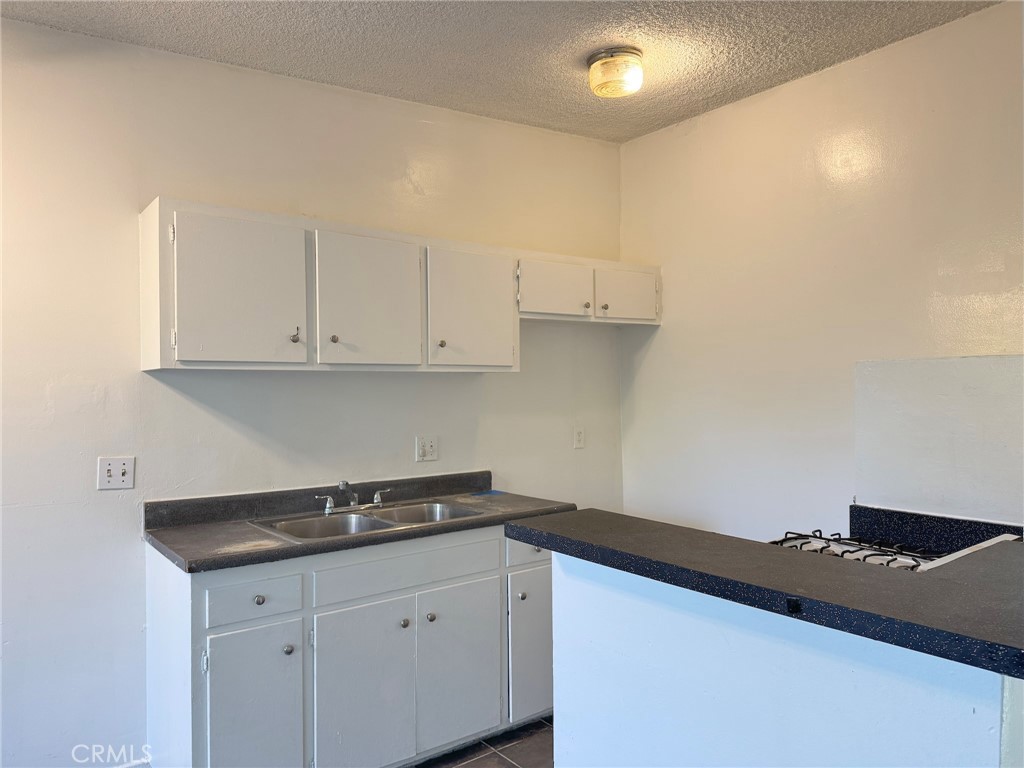 a kitchen with granite countertop white cabinets and a stove