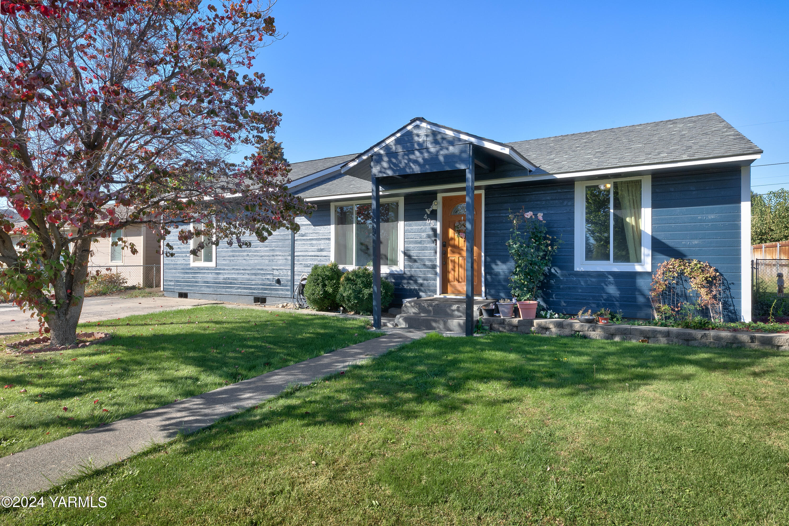 a front view of a house with a garden and plants