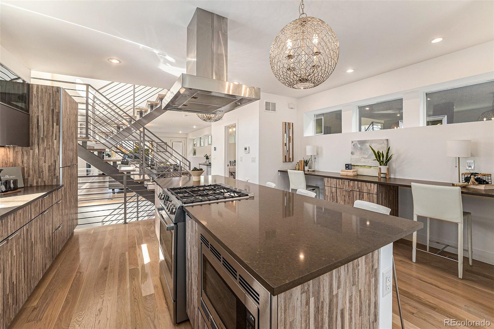 a kitchen with stainless steel appliances granite countertop a sink a stove and chairs