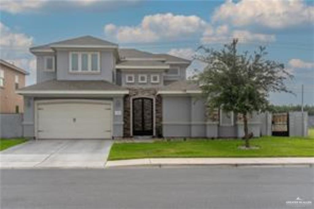 View of front facade with a front yard and a garage