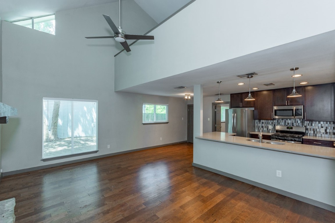 an open kitchen with window and wooden floor