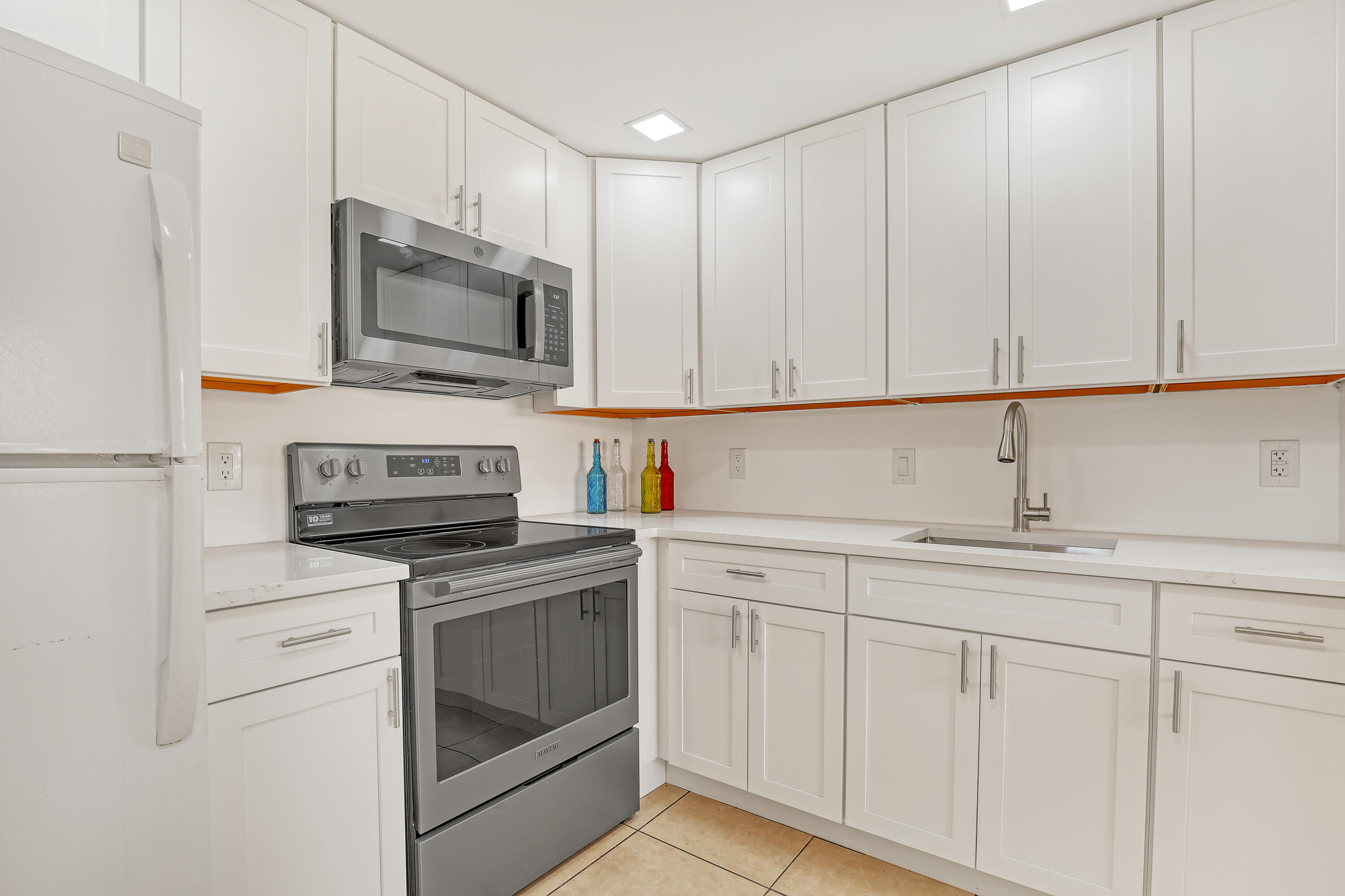 a kitchen with white cabinets and stainless steel appliances