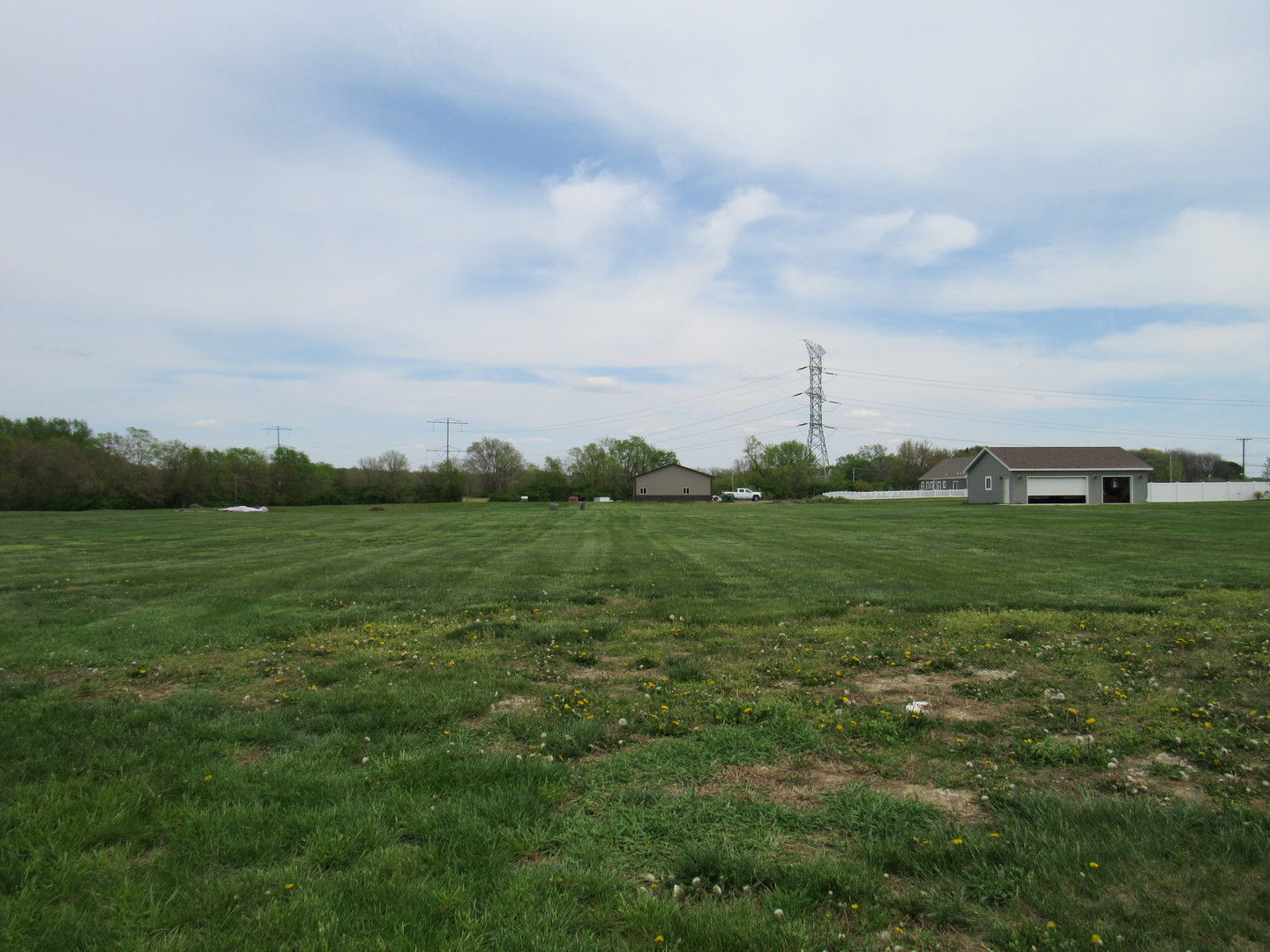 a view of a green field with wooden fence