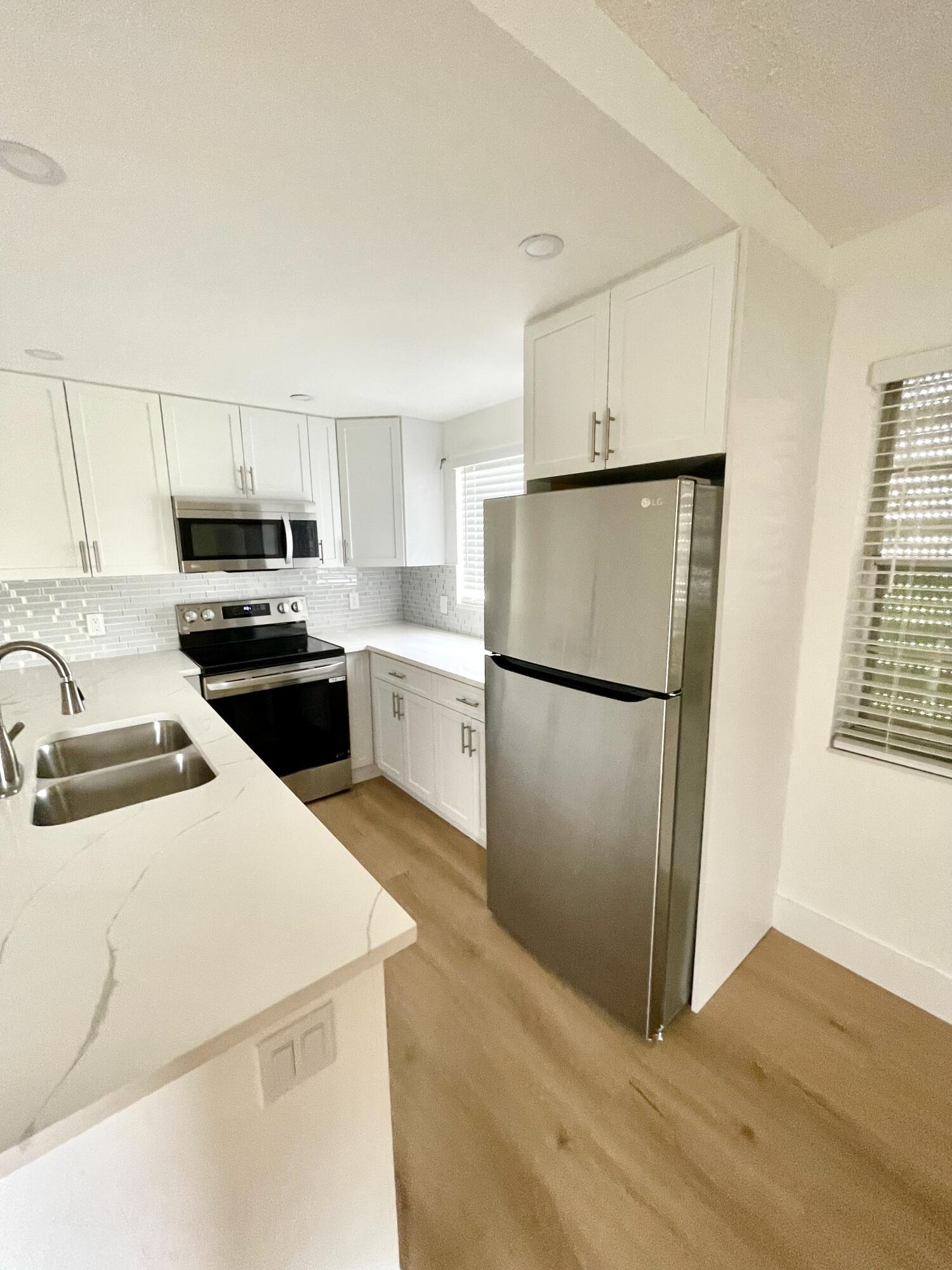 a kitchen with a refrigerator sink and cabinets