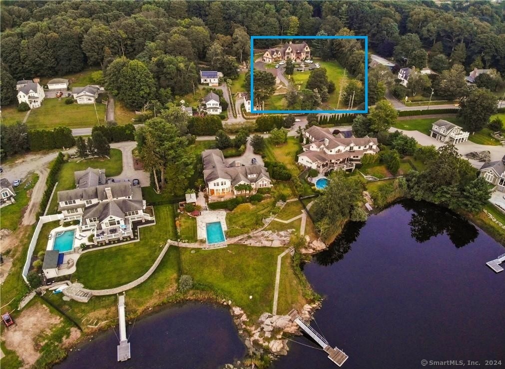 an aerial view of a house with a yard and lake view