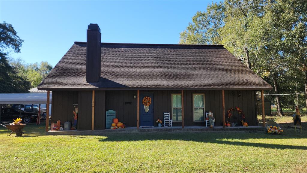 a view of a house with floor to ceiling windows and a yard