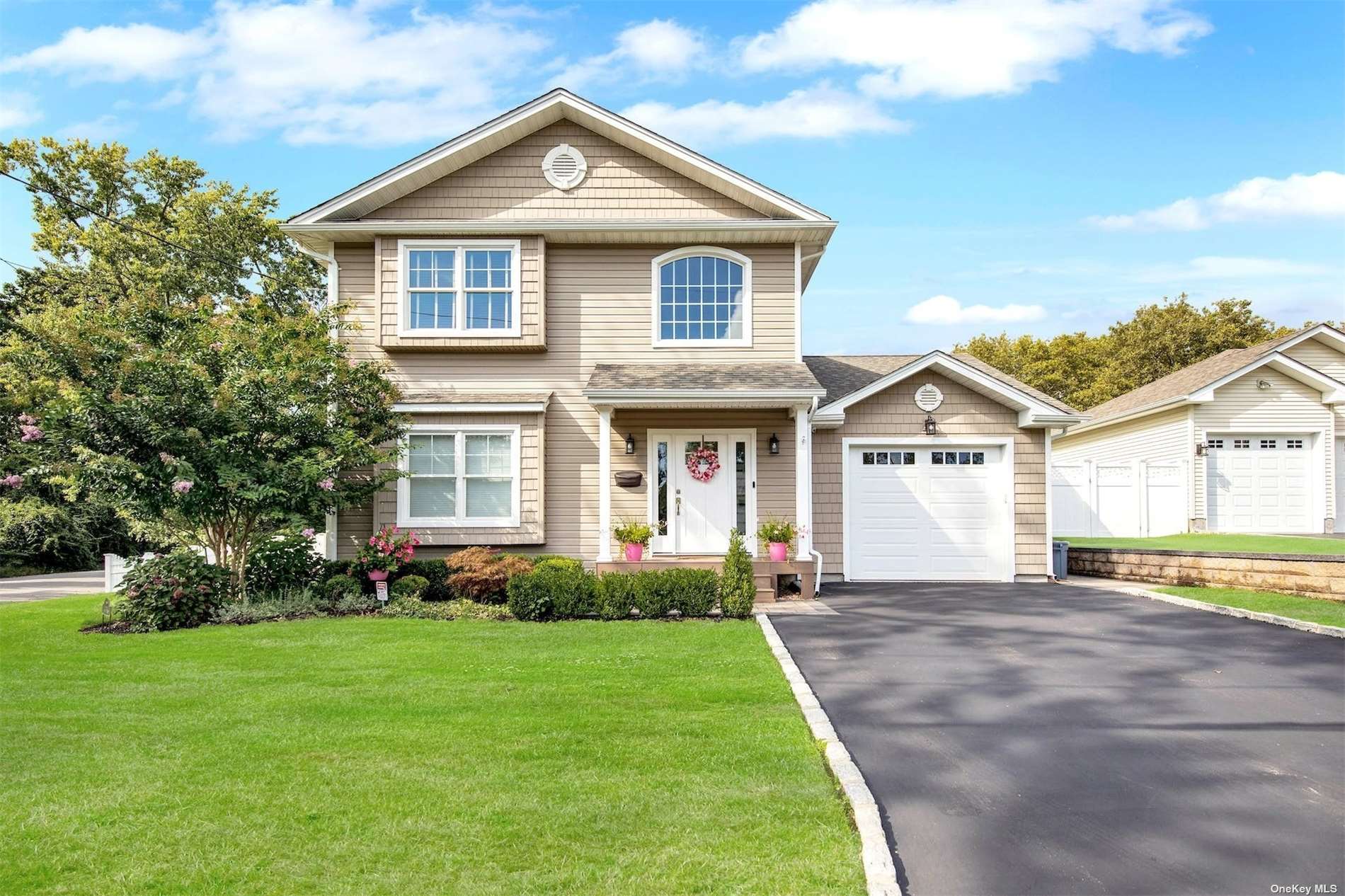 a front view of a house with a yard and trees