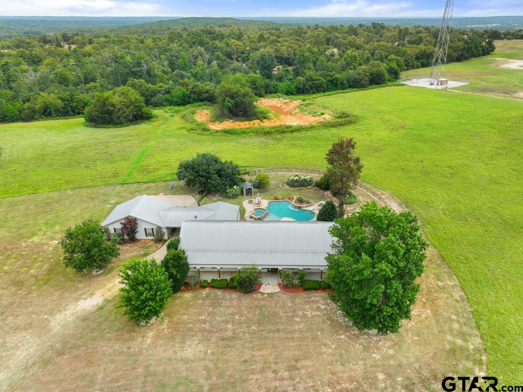 an aerial view of a houses with a yard and lake view