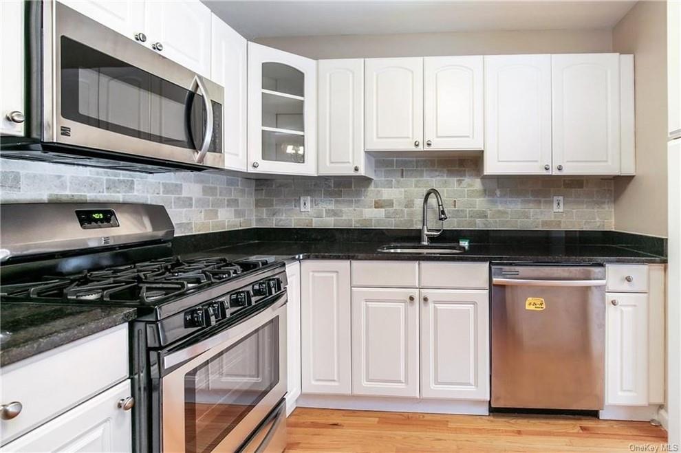 Kitchen with white cabinetry, appliances with stainless steel finishes, and sink