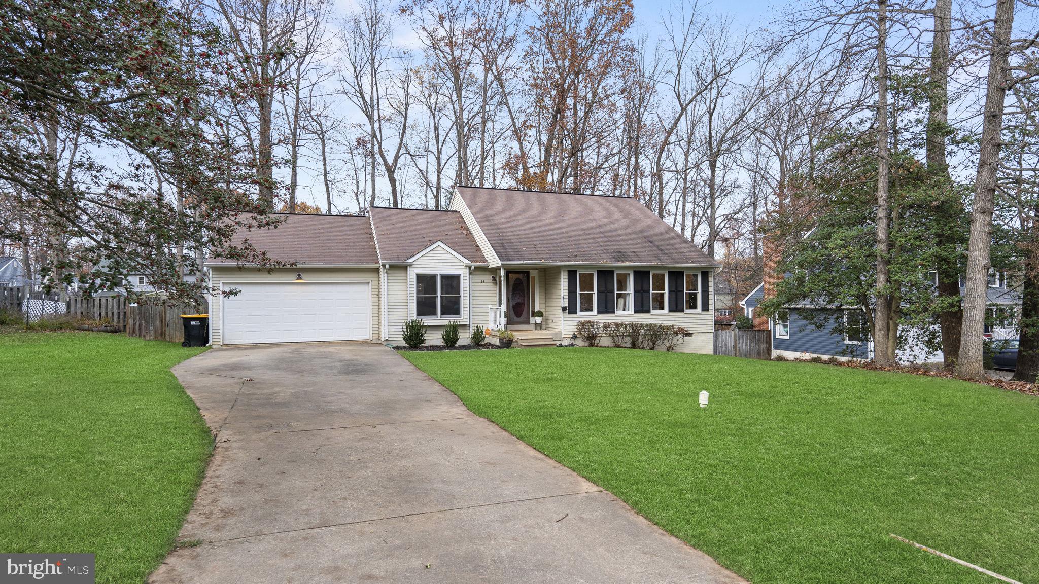 a front view of a house with a garden and trees