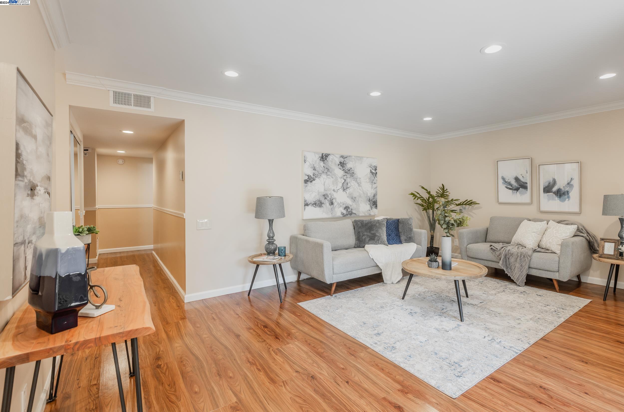 a living room with furniture and a wooden floor