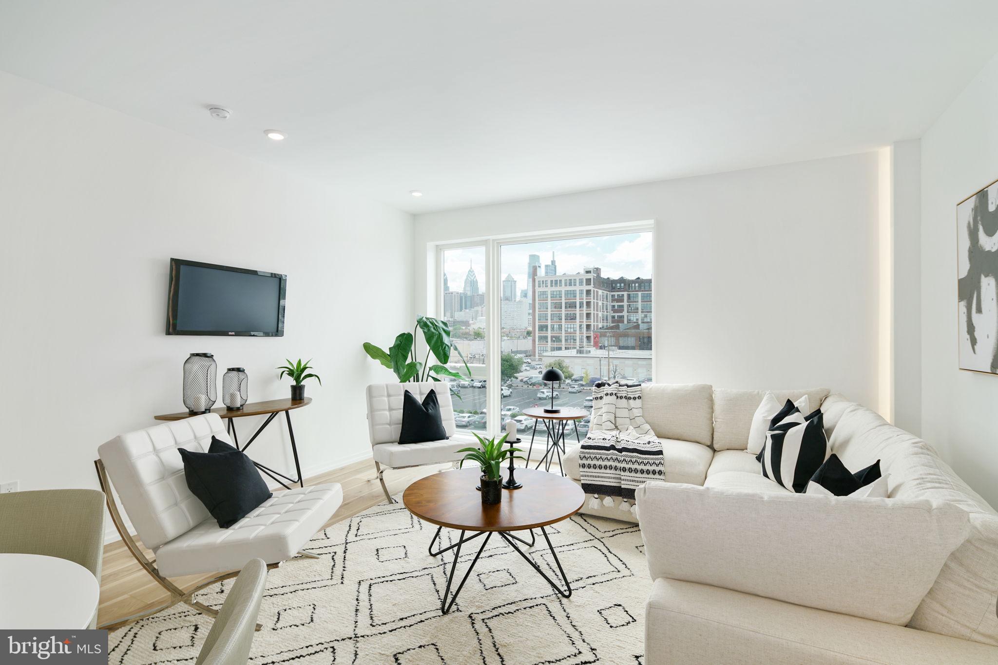 a living room with furniture a flat screen tv and a large window