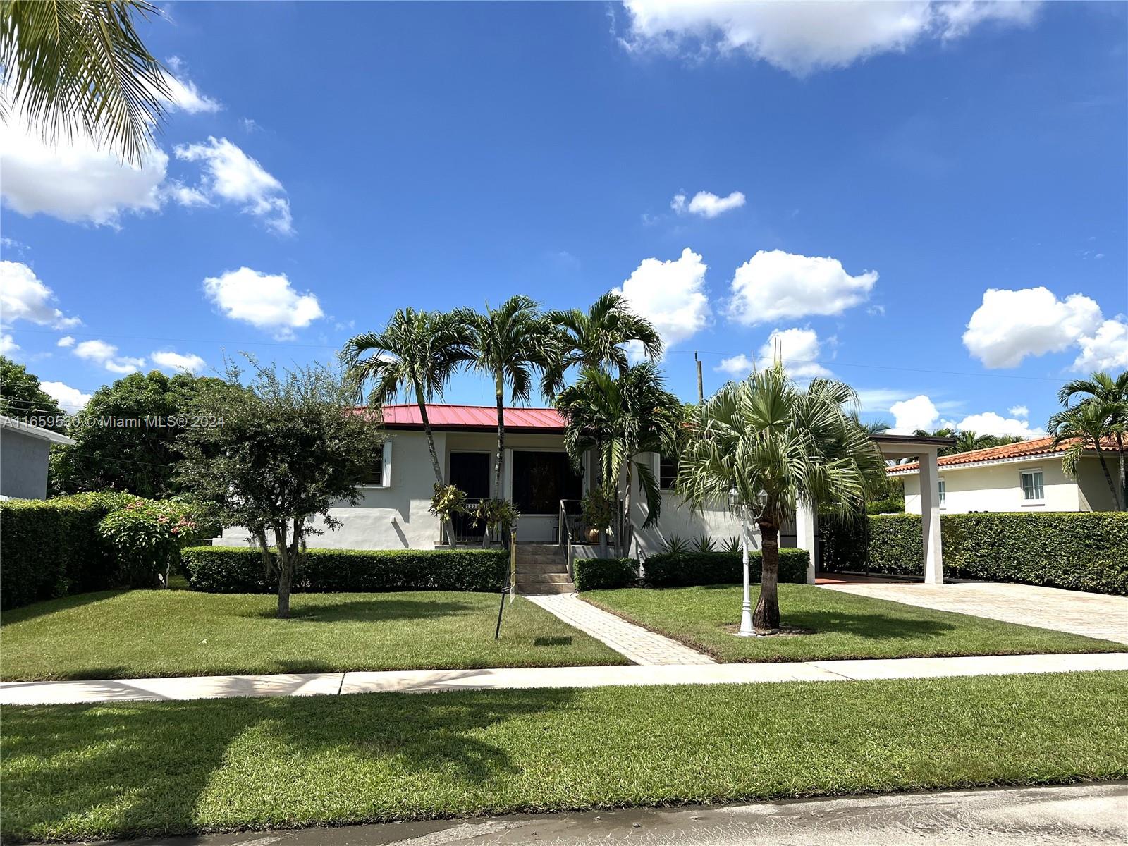 a front view of a house with a yard and green space