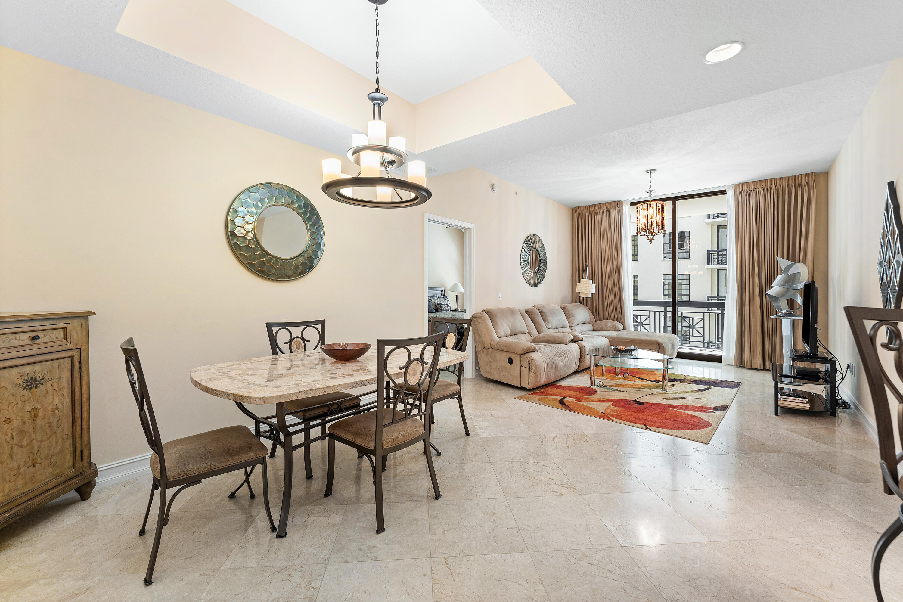 a view of a dining room and livingroom with furniture wooden floor a chandelier