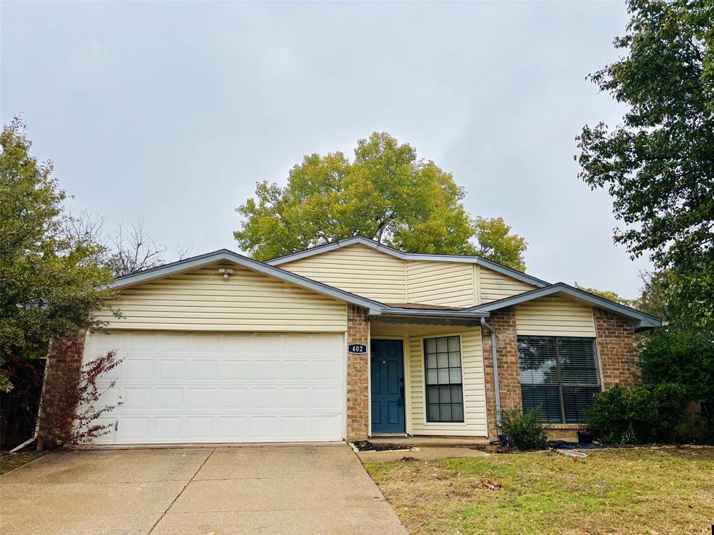 Ranch-style home with a garage and a front lawn