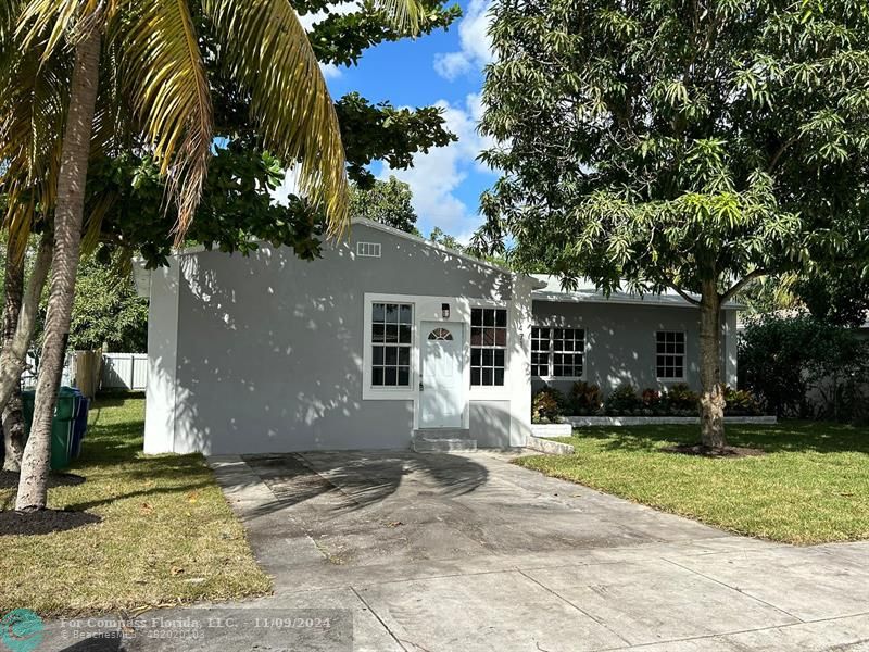 a front view of a house with a yard and trees