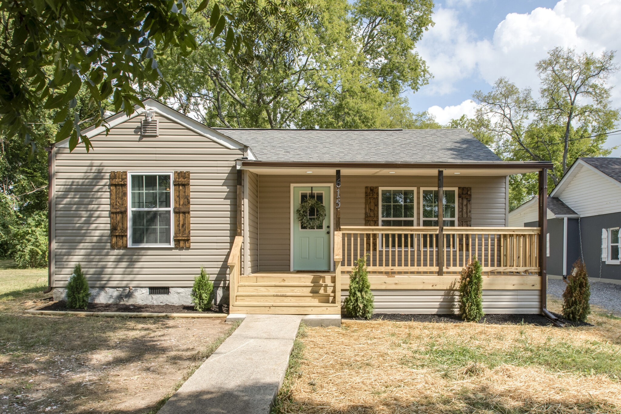 a front view of a house with a tree